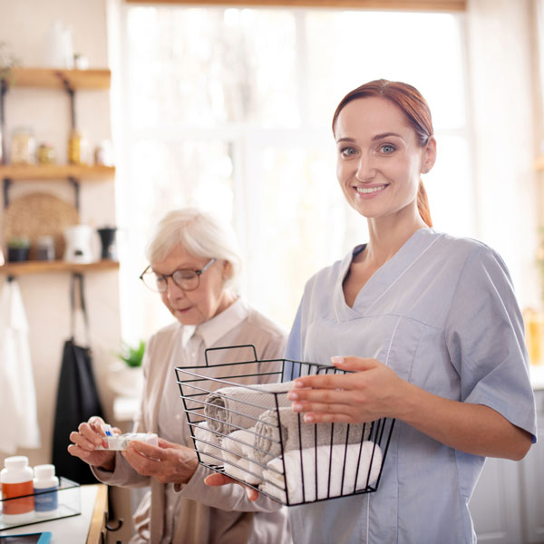 woman helping senior woman with chores