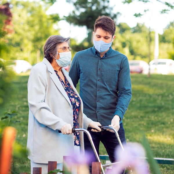 man helping senior woman walk